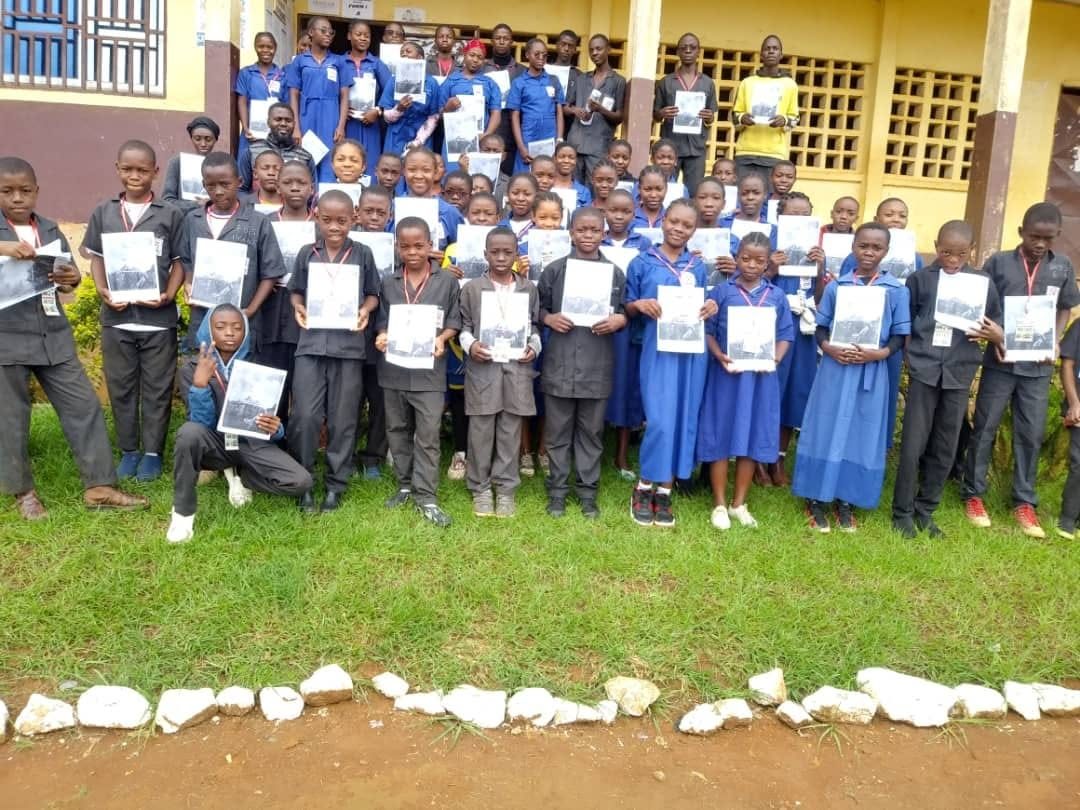 Student group holding leadership manuals outside school