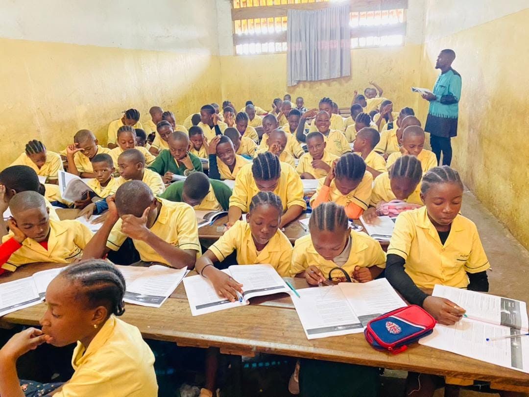 Students in yellow uniforms working through the leadership manual
